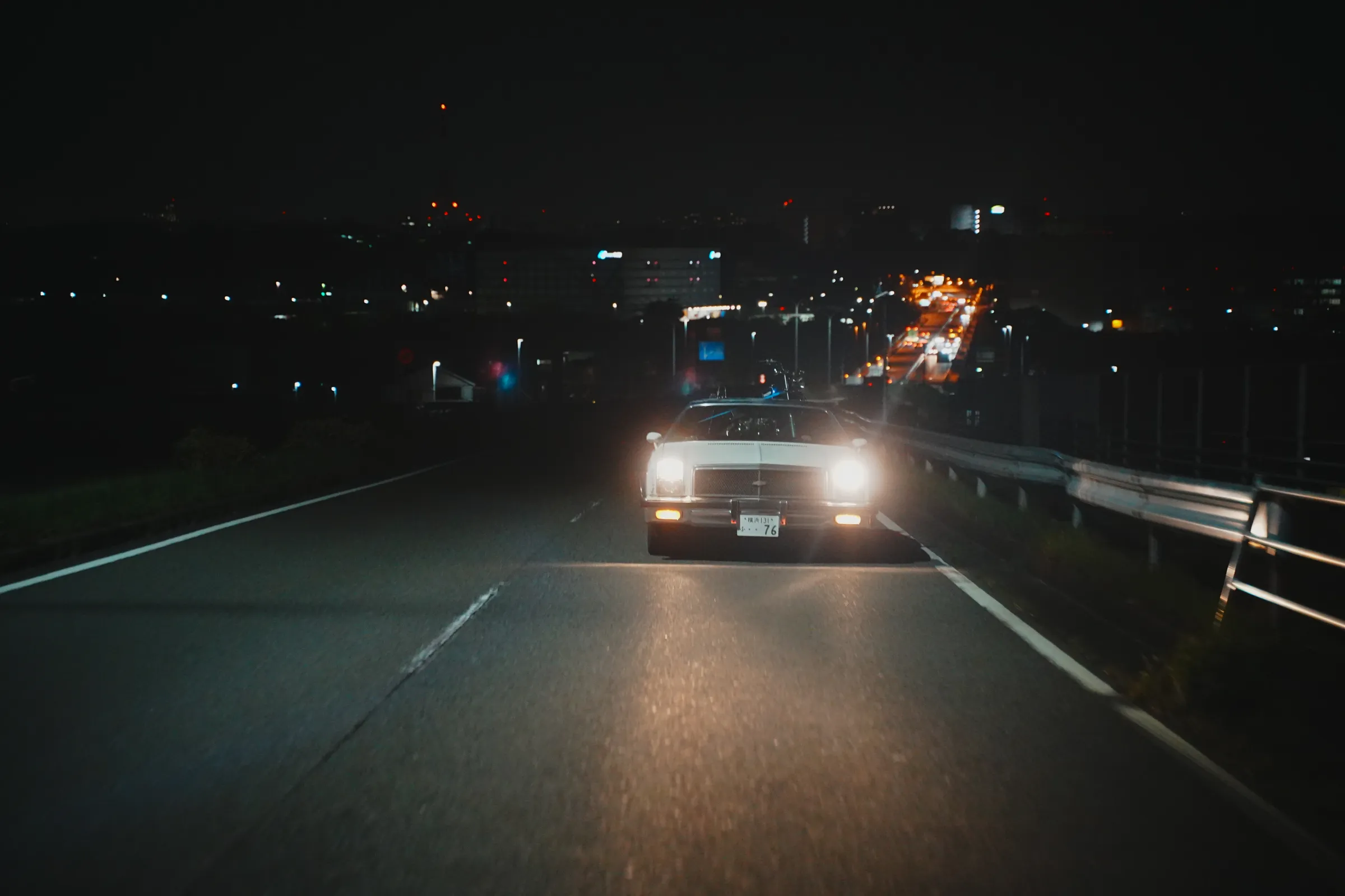 夜道を走るオープントップのアメ車